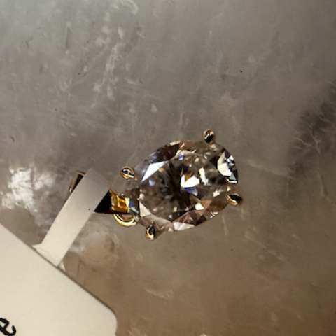 Diamond ring on a stand with a label on a reflective surface