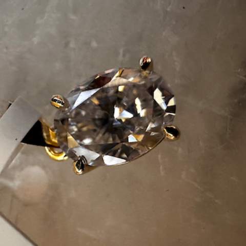 Diamond ring on a metallic stand against a textured gray background