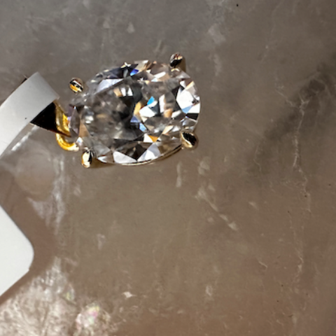 Diamond ring on a gray surface with a price tag.