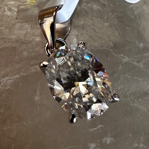 Diamond pendant on a gray surface