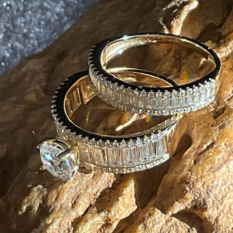 Three diamond rings stacked on a textured stone surface