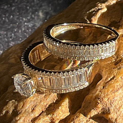 Two diamond rings stacked on a textured stone surface