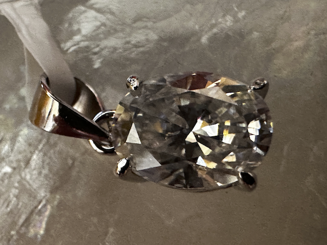 Diamond pendant on a metallic surface