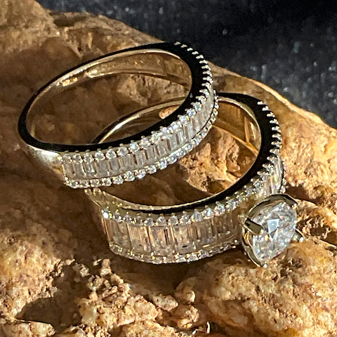 Two diamond rings stacked on a textured stone surface