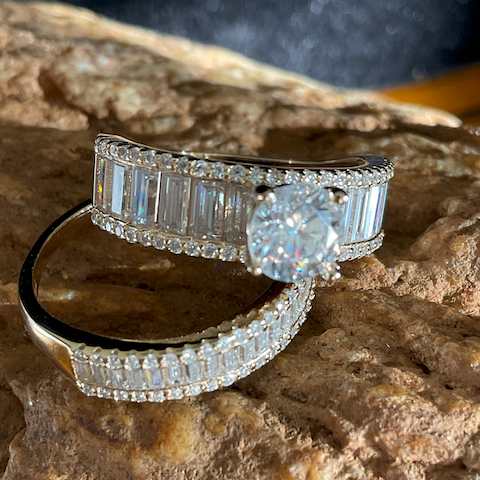 Diamond ring with baguette and round cut stones on a textured stone surface