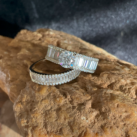 Diamond ring with baguette and round stones on a textured rock surface