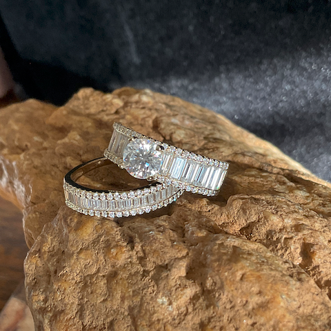 Two diamond rings on a textured stone surface