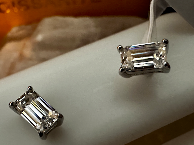 Pair of diamond earrings on a white surface