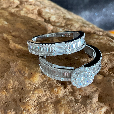 Two diamond rings stacked on a textured stone surface
