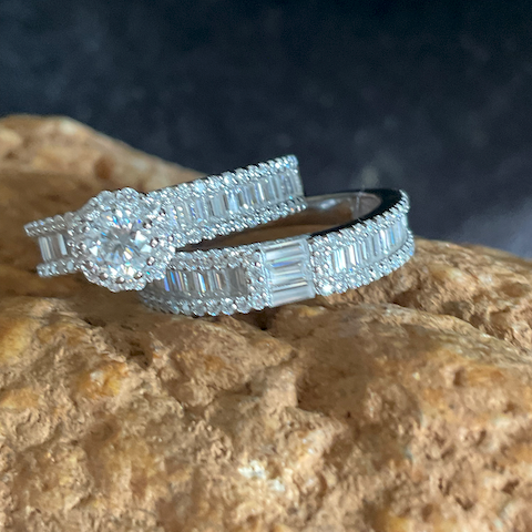 Silver ring with diamond accents on a textured stone surface