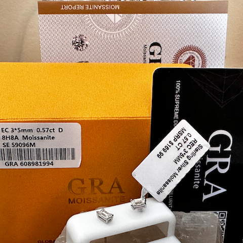 Jewelry with a grading certificate and box on a wooden surface