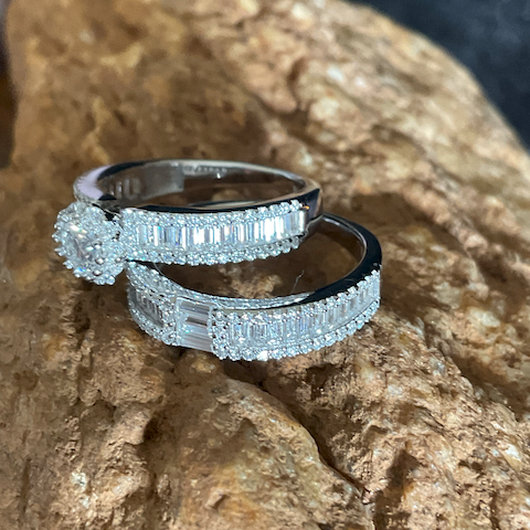 Two diamond rings stacked on a textured stone surface