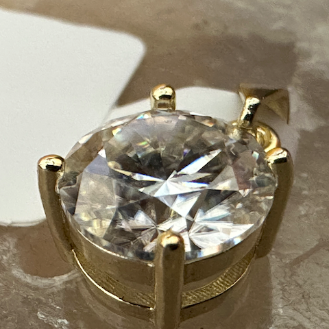 Gold ring with a large diamond on a textured surface