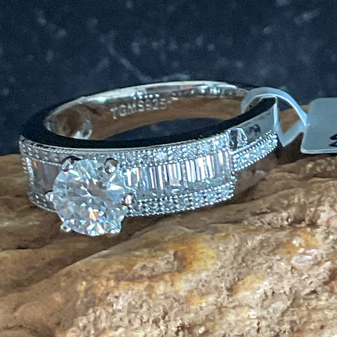 Silver ring with gemstone on a rock