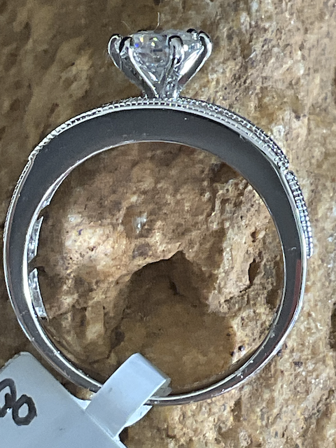 Silver ring with a stone on a textured surface