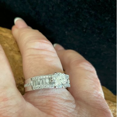 Diamond ring on a hand against a dark background