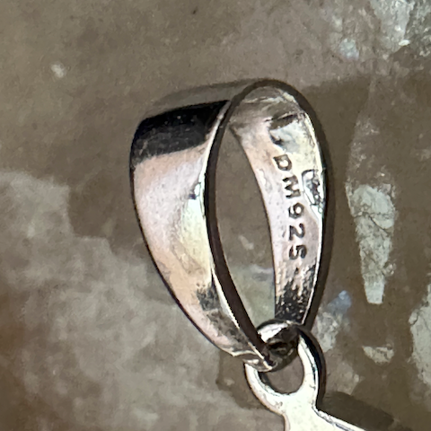 Silver ring with engraved text on a textured surface