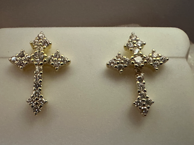 Pair of silver cross earrings on a white background