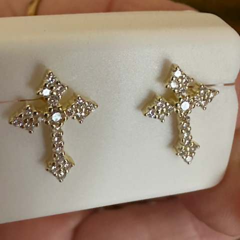 Silver cross earrings on a white jewelry box