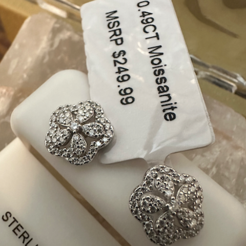 Silver earrings with a price tag on a white stand, featuring 'Sterling Silver' text.