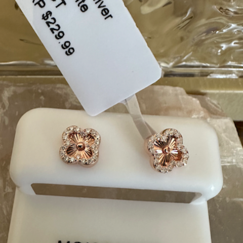 Pair of moissanite earrings on a display stand with a price tag.
