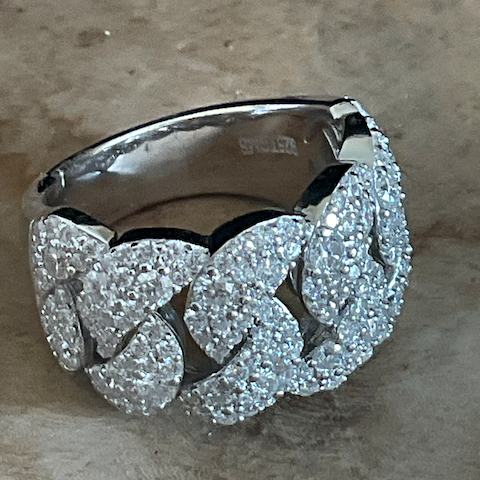 Silver ring with diamond-like stones on a textured surface
