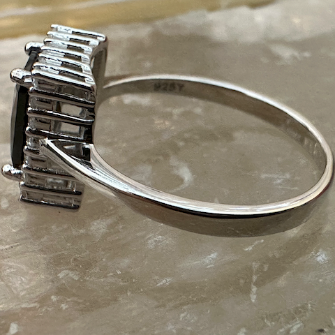 Silver ring with a diamond on a marble surface