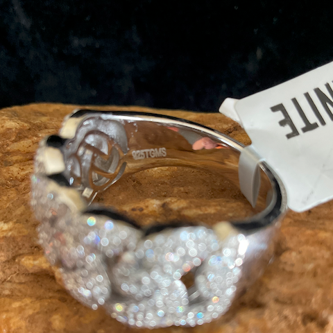 Silver ring with gemstones on a wooden surface