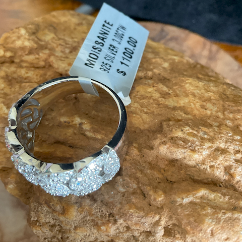 Silver ring with gemstones on a rock, price tag attached