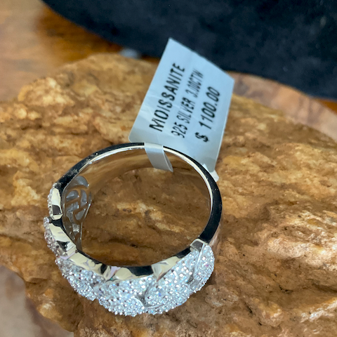 Silver ring with diamond accents on a rock, featuring a price tag.
