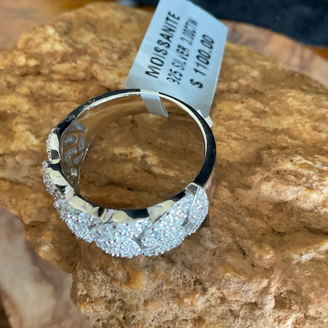 Silver ring with diamond accents on a rock, featuring a price tag.