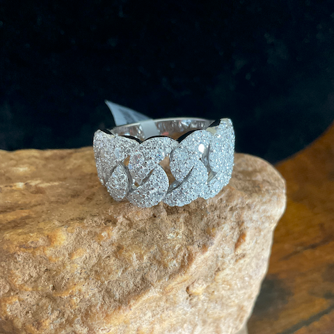 Silver ring with floral design on a stone surface