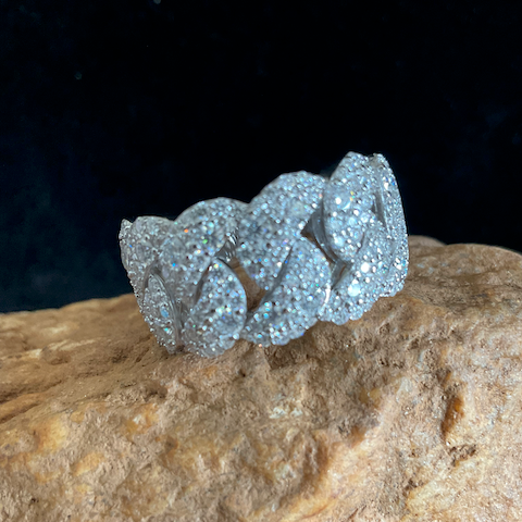 Silver ring with leaf design on a stone surface