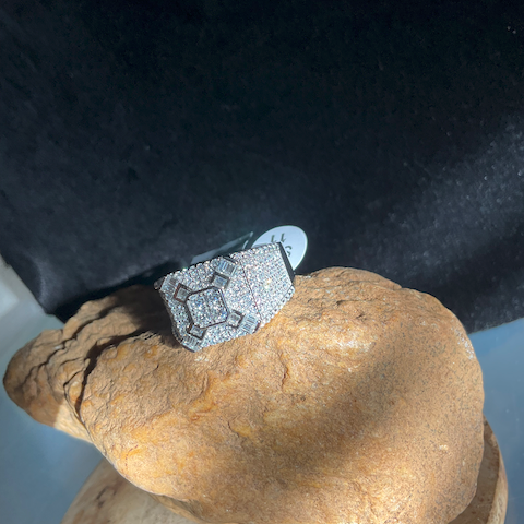 Silver ring with gemstones on a textured stone surface