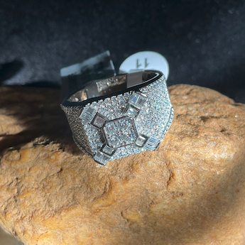 Silver ring with gemstones on a rock