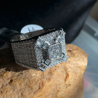 Silver ring with gemstones on a textured stone surface