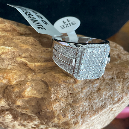 Silver ring with gemstones on a rock