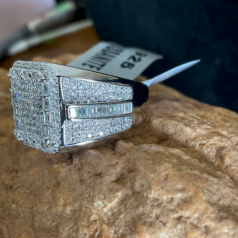 Silver ring with gemstones on a stone surface