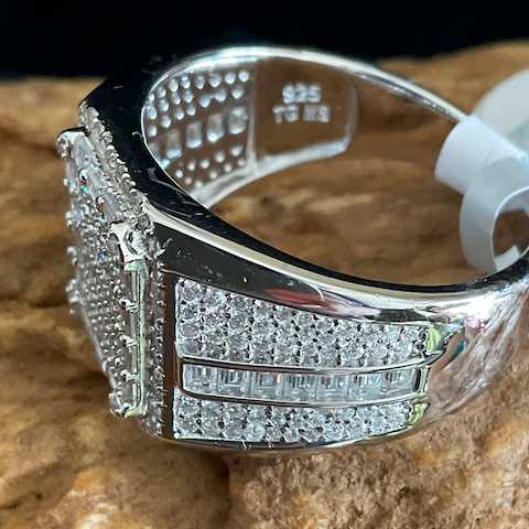 Silver ring with gemstones on a textured surface