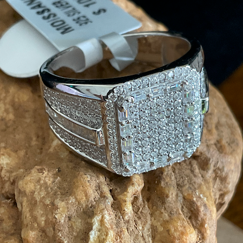 Silver ring with diamond accents on a stone surface