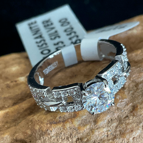 Diamond ring on a stone surface with a visible brand tag in the background