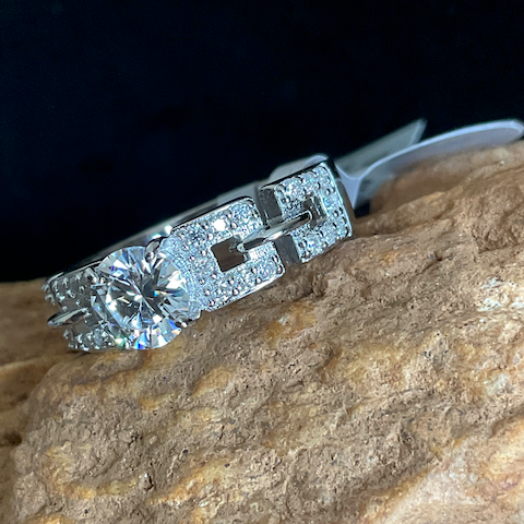 Silver ring with a large diamond on a stone surface