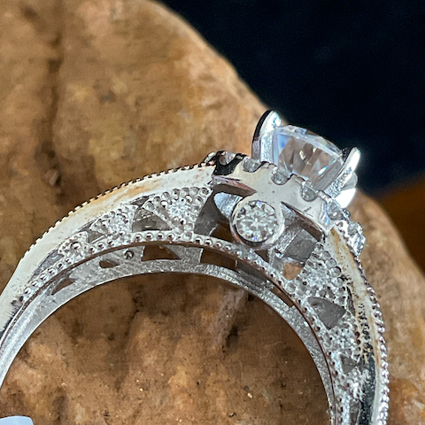 Silver ring with diamond accents on a stone surface