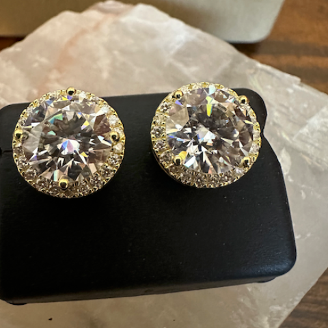 Pair of diamond earrings on a black stand with a blurred background