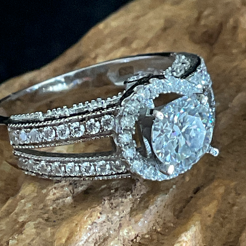 Silver ring with diamond accents on a stone surface