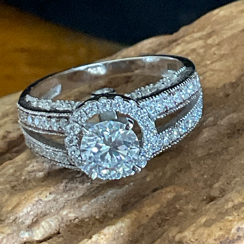 Silver ring with a large diamond on a stone surface