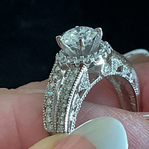 Elegant diamond ring on a hand with a dark background