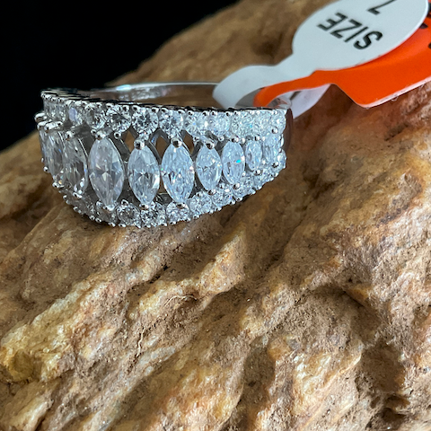 Silver ring with gemstones on a stone surface