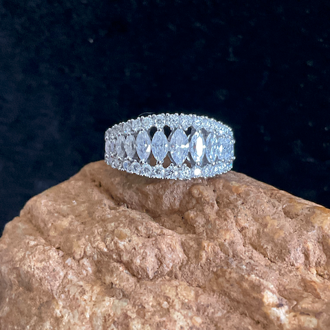 Silver ring with gemstones on a textured stone surface