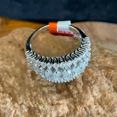 Silver ring with decorative design on a stone surface